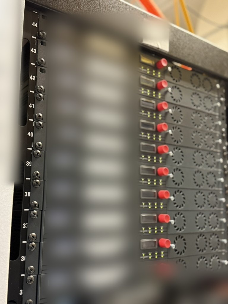 The rack of Riedel MediorNet MicroN nodes behind the temporary backbone — network identifiers blurred