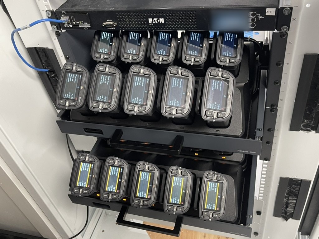 Bolero beltpacks in their rack-mounted charging bays, backed-up power at the top of the bay